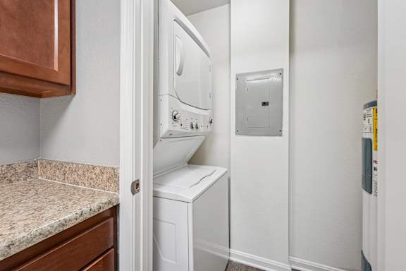 A white dryer is in a small laundry room.